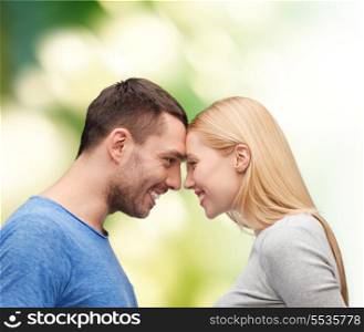 love and family concept - smiling couple looking at each other