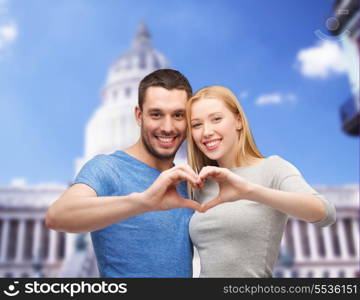 love and family concept - smiling couple showing heart with hands