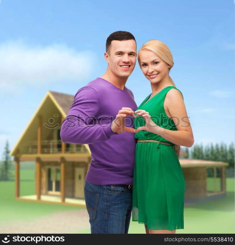 love and family concept - smiling couple showing heart with hands