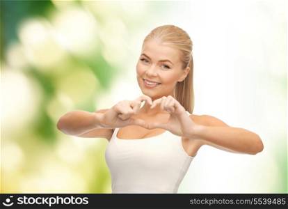 love and gesture concept - smiling woman showing heart shape gesture