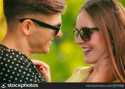 Love and happiness. Young happy couple lovers wearing sunglasses dating in summer park outdoor.. Happy couple in park