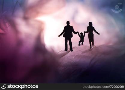 Love and Happy Family. Exploration for Children and Parent. Miniature of Father, Mother and Son holding Hands and Walking on a Mystery Dark Place