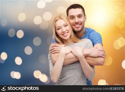 love and people concept - happy couple hugging over lights background. happy couple hugging over lights background