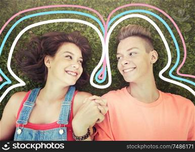 love and people concept - happy teenage couple lying on grass at summer with glowing lines. happy teenage couple lying on grass at summer