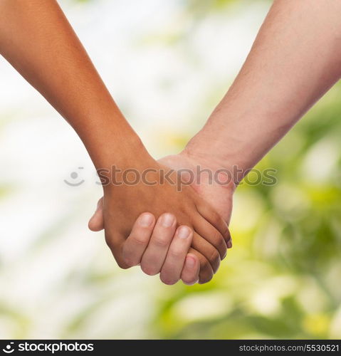 love and relationships concept - closeup of woman and man holding hands