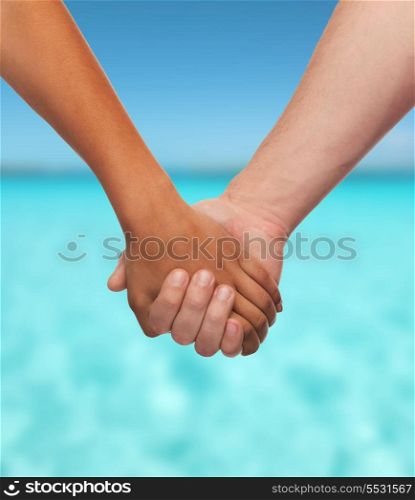 love and relationships concept - closeup of woman and man holding hands