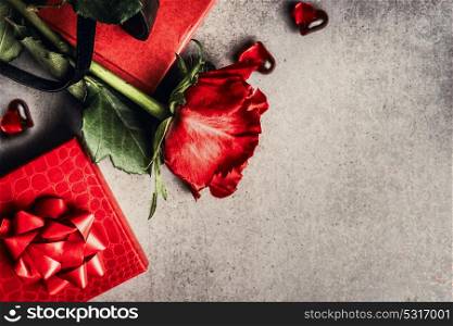 Love and Valentines day greeting card with red roses, gifts and hearts on gray background, top view, place for text