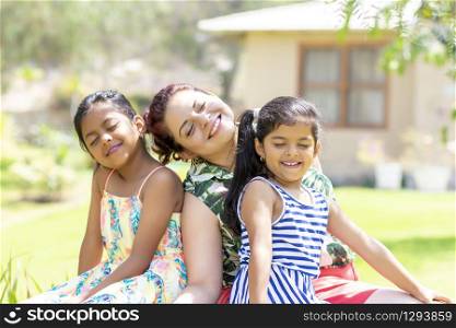 Love between a young mother and her two pretty daughters outdoors