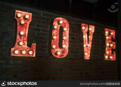 LOVE bulb sign decorated on brick wall, stock photo