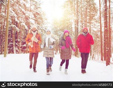 love, christmas, season, friendship and people concept - group of smiling men and women running in winter forest