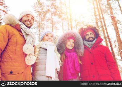 love, christmas, season, friendship and people concept - group of smiling men and women walking in winter forest