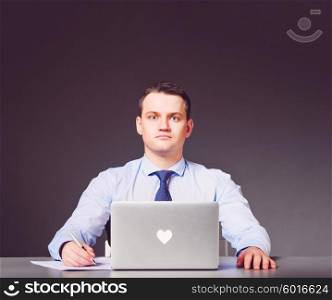 love concept. businessman with is sitting at his table with heart-labeled laptop. businessman with laptop