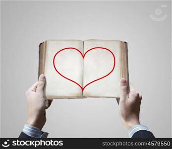 Love concept. Close up of male hands holding opened book