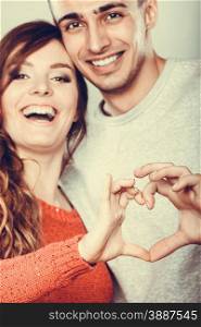 Love concept. Closeup Smiling woman and man forming heart shape with their fingers hands