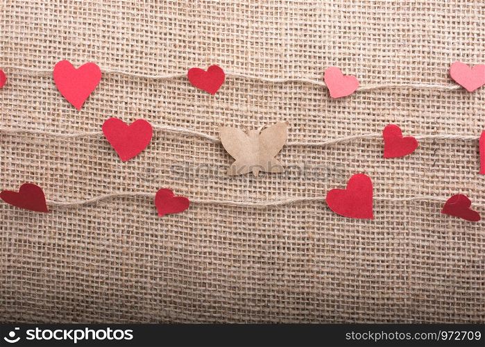 Love concept with heart shaped papers on linen threads