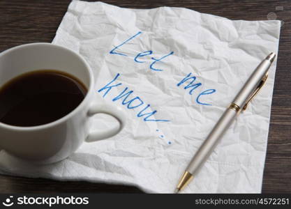 Love confession on napkin. Romantic message written on napkin and cup of coffee on wooden table