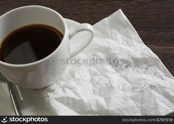 Love confession on napkin. Romantic message written on napkin and cup of coffee on wooden table