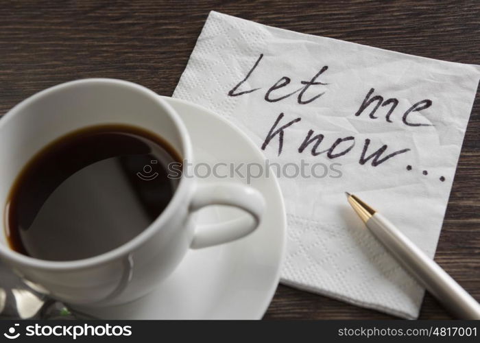 Love confession on napkin. Romantic message written on napkin and cup of coffee on wooden table