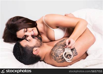 Love couple flirting and hugging in bed