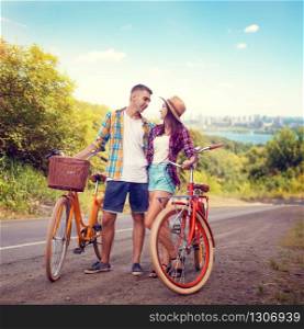 Love couple hugs on road, vintage bike, romantic travel of young man and woman. Boyfriend and girlfriend together outdoor, retro bicycle. Couple hugs on road, vintage bike, romantic travel