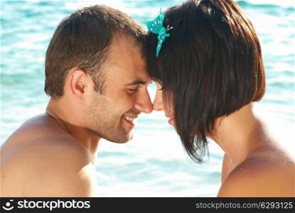 Love couple on the beach against water backdround