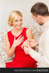 love, couple, relationship and dating concept - romantic man proposing to a woman in red dress