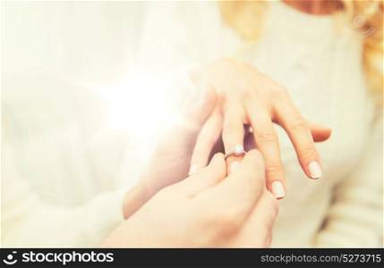love, couple, relationship and holidays concept - close up of man giving diamond ring to woman. close up of man giving diamond ring to woman