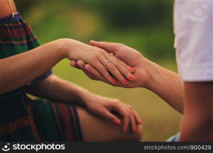 love, couple, relationship and holidays concept - close up of man giving diamond ring to woman. hands of a young couple with a ring. hands of a young couple with a ring. love, couple, relationship and holidays concept - close up of man giving diamond ring to woman