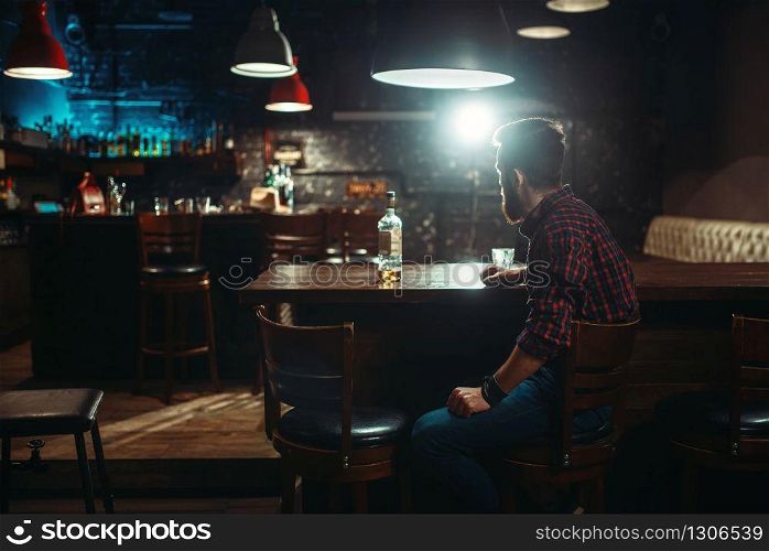 Love couple with alcoholic beverages standing against bar counter, romantic evening. Lovers leisures in pub, husband and wife relaxing together in nightclub. Love couple standing against bar counter