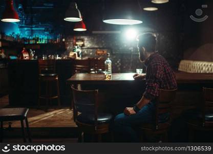 Love couple with alcoholic beverages standing against bar counter, romantic evening. Lovers leisures in pub, husband and wife relaxing together in nightclub. Love couple standing against bar counter