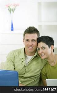 Love couple working together on laptop computer at home.