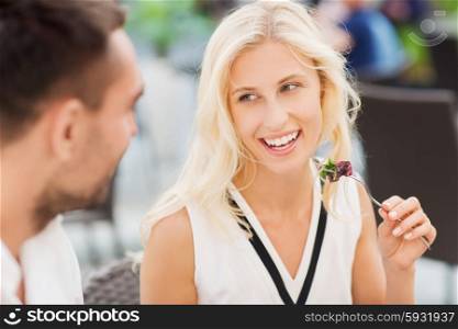 love, date, people, holidays and relations concept - happy couple eating salad for dinner at cafe or restaurant terrace