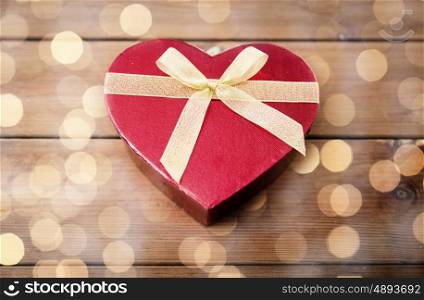 love, date, romance, valentines day and holidays concept - close up of heart shaped gift box on wood (vintage effect)