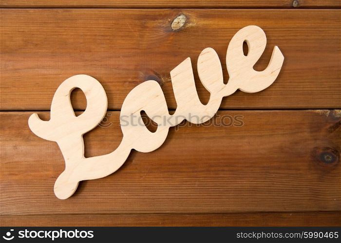 love, date, romance, valentines day and holidays concept - close up of word love cutout on wood