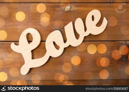 love, date, romance, valentines day and holidays concept - close up of word love cutout on wood