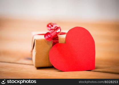 love, date, romance, valentines day and holidays concept - close up of gift box and blank red heart-shaped note on wood