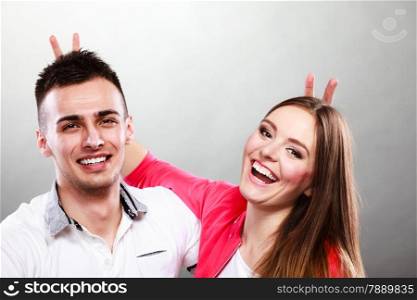 Love dating and people concept. Smiling young couple having fun on gray