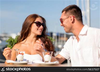 love, dating, people and food concept - smiling couple smiling couple wearing sunglasses eating dessert and looking to each other at cafe