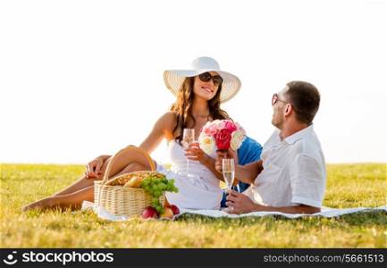love, dating, people and holidays concept - smiling couple drinking champagne on picnic