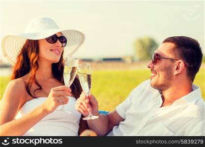 love, dating, people and holidays concept - smiling couple drinking champagne on picnic