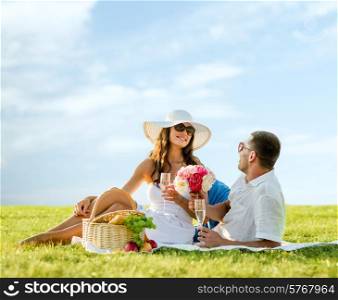 love, dating, people and holidays concept - smiling couple drinking champagne on picnic outdoors