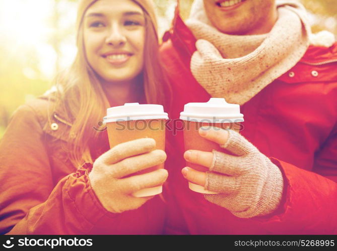 love, drinks and people concept - close up of happy young couple with coffee cups in autumn park. close up of happy couple with coffee in autumn