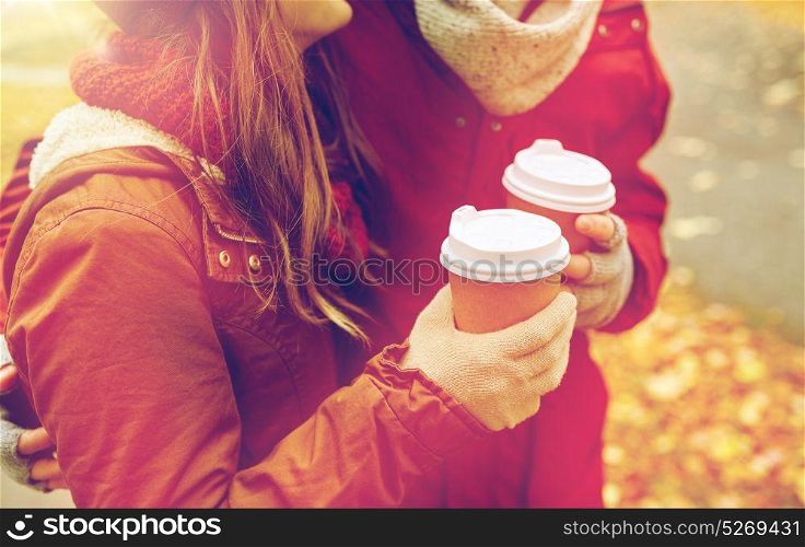 love, drinks and people concept - close up of happy young couple with coffee cups in autumn park. close up of happy couple with coffee in autumn
