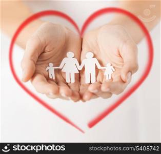 love, family and happiness concept - close up of womans hands showing paper man family