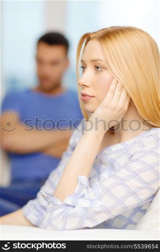 love, family and happiness concept - upset young woman with man on the back at home