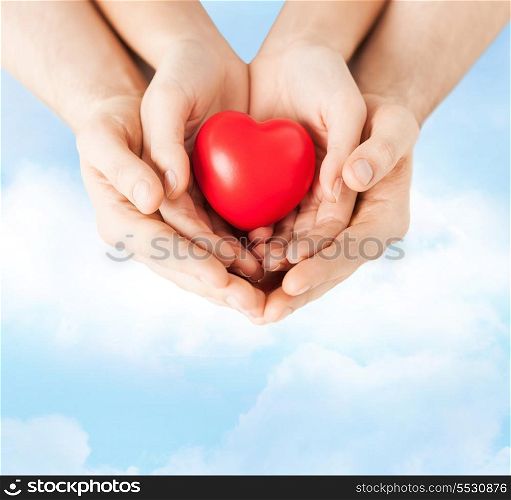 love, family and relationships - closeup of woman and man hands with heart