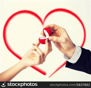 love, family, anniversary concept - couple hands with engagement ring