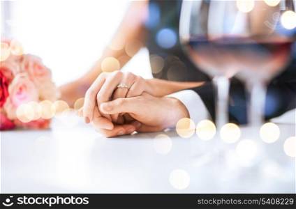 love, family, anniversary concept - engaged couple with wine glasses in restaurant