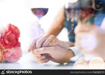 love, family, anniversary concept - engaged couple with wine glasses in restaurant
