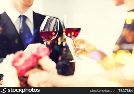 love, family, anniversary concept - engaged couple with wine glasses in restaurant